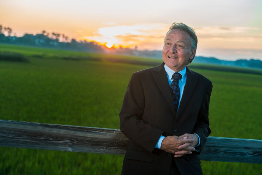 Dr. Richard Greco, board-certified plastic surgeon, standing outdoors at sunset